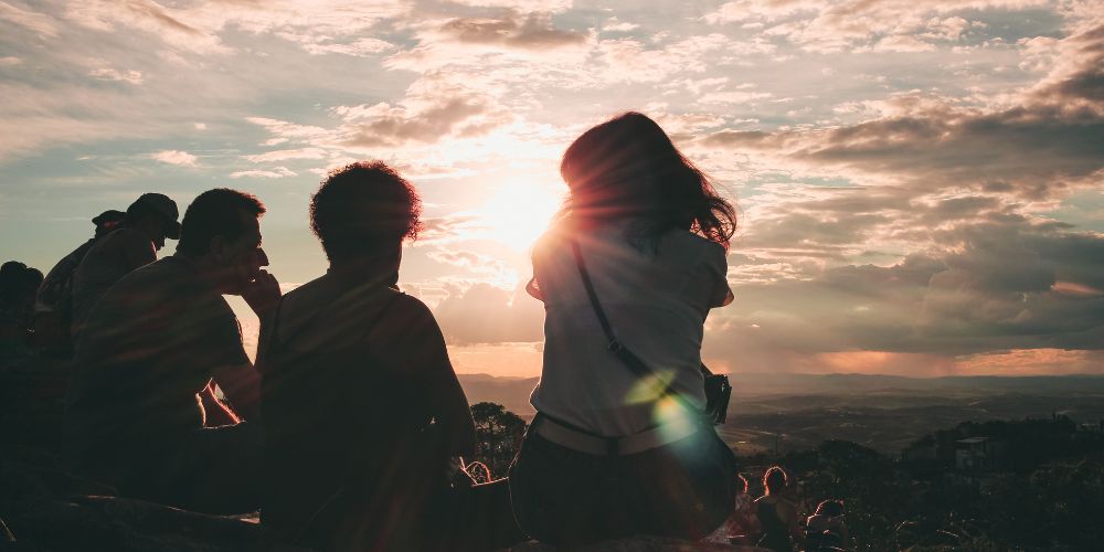 Un gruppo di amici in cima a una collina che stanno ammirando il panorama esprimendo come Credem supporto ai suoi clienti