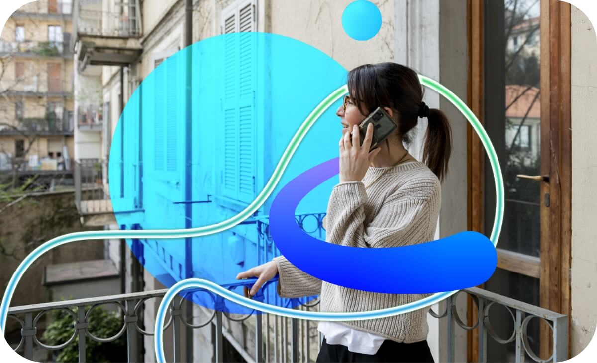 Una dipendente Credem in carriera che sta parlando al cellulare sul balcone di casa sua ed è contornata da una grafica a forme irregolari che sta a rappresentare l’energia positiva da lei trasmessa.