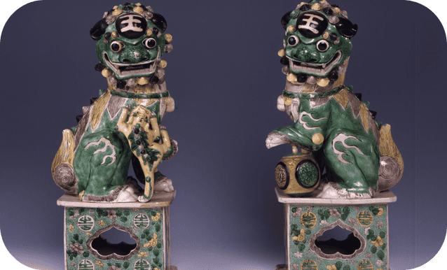 Statue in porcellana cinese verde, oro e nero dei Leoni con l’aspetto di alcune razze di cani di origine sino-tibetana dagli grandi occhi tondi e dal pelo lungo.